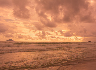 Photo of golden beach at sunset with island on the horizon