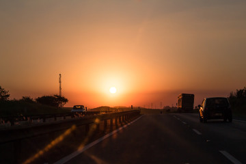 Photo of cars and truck on road at sunset