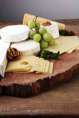 Cheese platter with different cheese on brown wooden plate