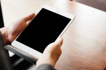 top view. business man holding tablet touch on black screen. sitting at coffee cafe in morning time. image for business,education,mobile,technology,workplace,people concept