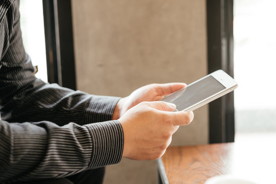 business man holding tablet touch on black screen. sitting at coffee cafe in morning time. image for business,education,mobile,technology,workplace,people concept