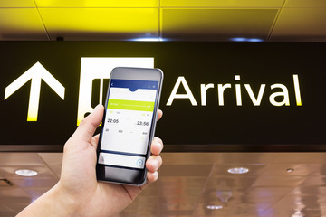 mobile phone with arrival sign in airport