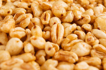 Puffed honey air rice wheat closeup background. Cereals texture.
