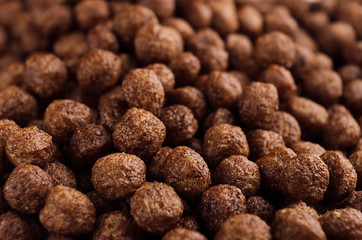 Chocolate balls corn flakes closeup background. Cereals texture.