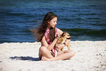 Fototapeta na wymiar Girl gently stroking the dog on the sea beach