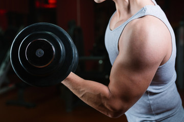 Closeup of a person holding an weights, with head cropped. Bodybuilding concept.