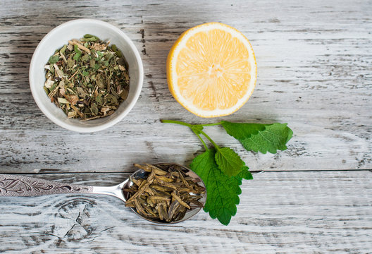 Leaves of green tea, lemon and collection of useful herbs in a bowl. The concept of healthy eating.