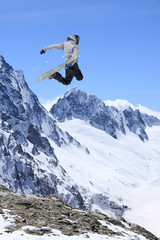 Fototapeta na wymiar Snowboarder jumping in the mountains. Extreme sport.