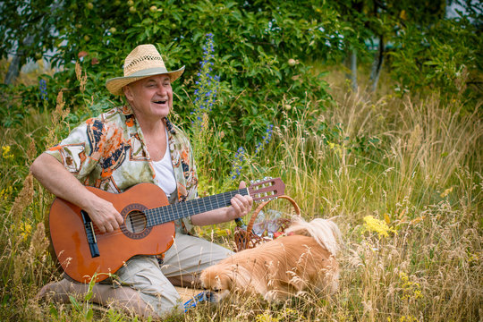 Old european man on a picnic with his dog have fun and sing song