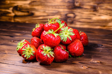 Ripe strawberries in glass bowl on wooden table