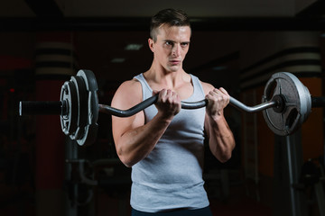 Naklejka na ściany i meble Closeup portrait of a muscular man workout with barbell at gym. Deadlift barbells workout.