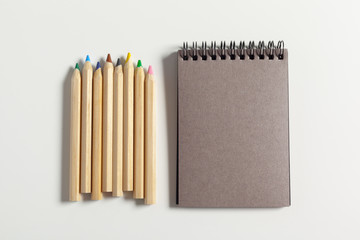 Obraz premium colored pencils and notepad on the table