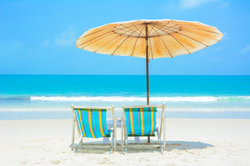 Blue sea and white sand beach with beach chairs and parasol