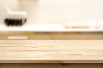Wood table top (as kitchen island) on blur kitchen interior background