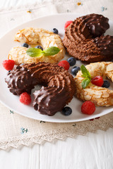 Almond and chocolate cookies in the shape of a horseshoe with fresh berries close-up. Vertical