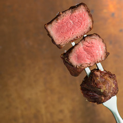 sliced steaks impaled on meat fork