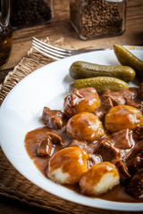Stew served with silesian noodles and sauce.
