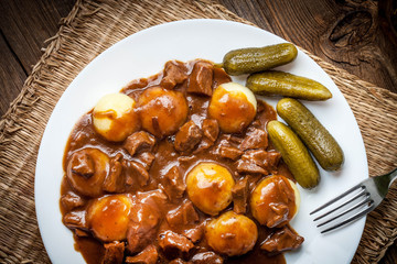 Stew served with silesian noodles and sauce.