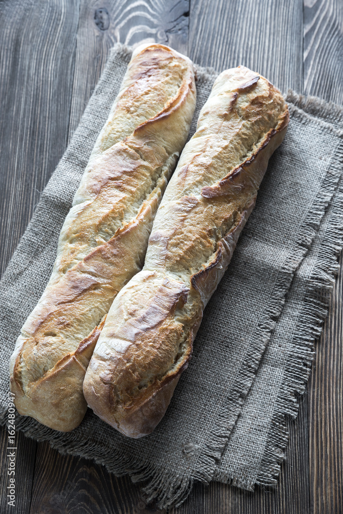 Wall mural two baguettes on the wooden background