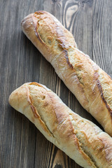 Two baguettes on the wooden background