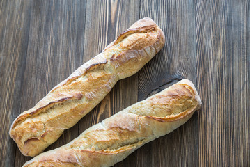 Two baguettes on the wooden background