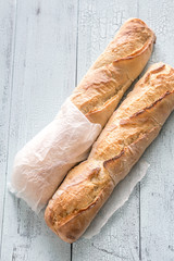Two baguettes on the wooden background