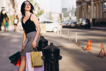 Fashionably dressed woman with colored shopping bags, shopping concept