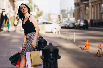 Fashionably dressed woman with colored shopping bags, shopping concept