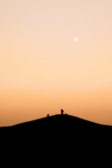 Fototapeta na wymiar Halde in Gelsenkirchen mit zwei Menschen auf dem Gipfel während Sonnenuntergang