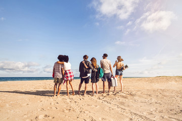 Back view of young men and woman on sea shore