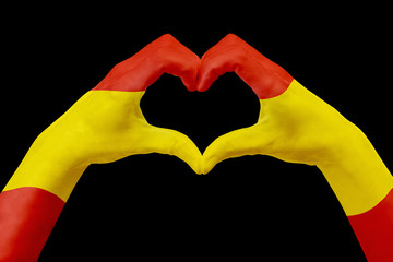 Fototapeta premium Hands flag of Spain, shape a heart. Concept of country symbol, isolated on black.