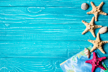 Seashells and map on blue wooden background
