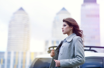 Fototapeta premium Young pretty girl, spring outdoor portrait. Beautiful woman runing against the backdrop of the urban landscape