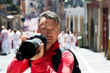 Photographer on San Fermin. Photojournalist. People celebrate San Fermin festival in traditional...