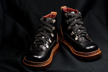 Beautifully lit with natural light a pair of polished man's shoes against a dark background. Close-up.