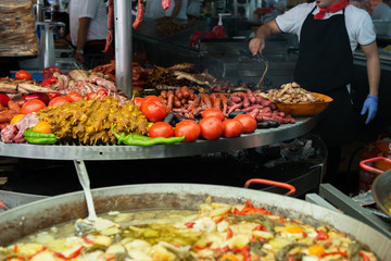 Street food in San Fermin feast, Pamlona, Navarra, Spain. Paella. Rise with seafood and vegetables. Spanish traditional cuisine. Spanish national dish, image toned and noise added.