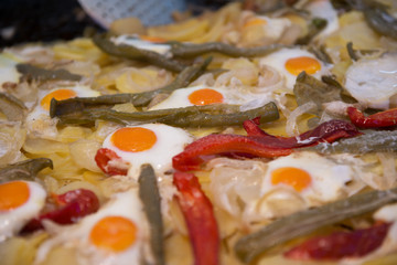 Street food in San Fermin feast, Pamlona, Navarra, Spain. Fried eggs. Scrambled eggs with vegetables. Spanish traditional cuisine. Spanish national dish.