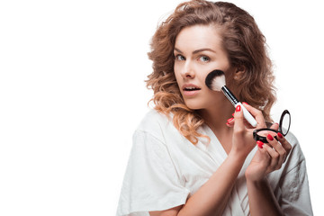 Elegant blonde woman applying blush with brush isolated on white