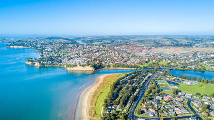 Aerial view on sunny beach with residential suburb on the background. Auckland, New Zealand. - obrazy, fototapety, plakaty