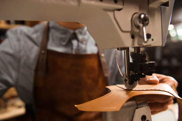 Close up of a cobbler using sewing machine