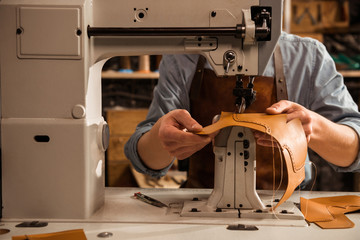 Close up of a cobbler using sewing machine
