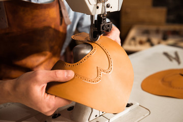 Close up of a bootmaker working with leather textile
