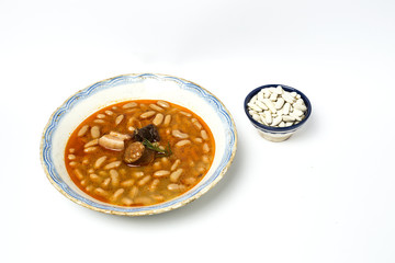 Stew of beans with chorizo and pork.Isolated