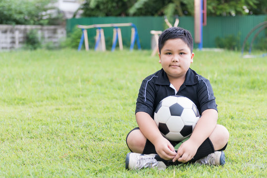 sitting obese fat boy  soccer player with football