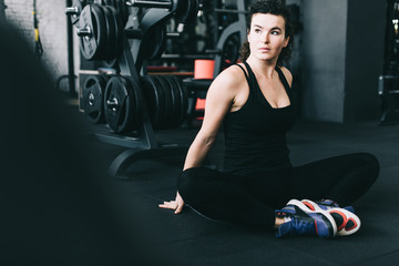 Fototapeta na wymiar Flexible young woman relaxing in the gym