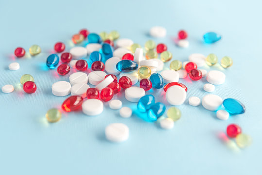 Close up of colorful capsules and white tablets