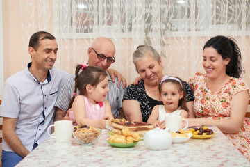 big family drinking tea in dining room
