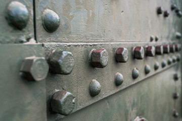 Abstract green industrial metal background texture with bolts and rivets. Old painted metal...
