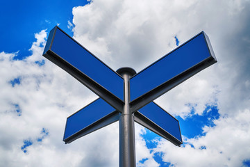 Blank blue traffic road signs in bright sky with clouds, free space for text. Blank street sign on cloudy sky background, copy space