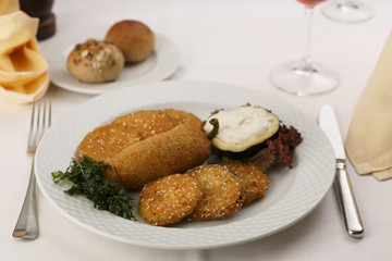 Breaded and fried red bell pepper and eggplant arranged on a plate, Traditional dish in elegant setting, Selective focus with soft light
